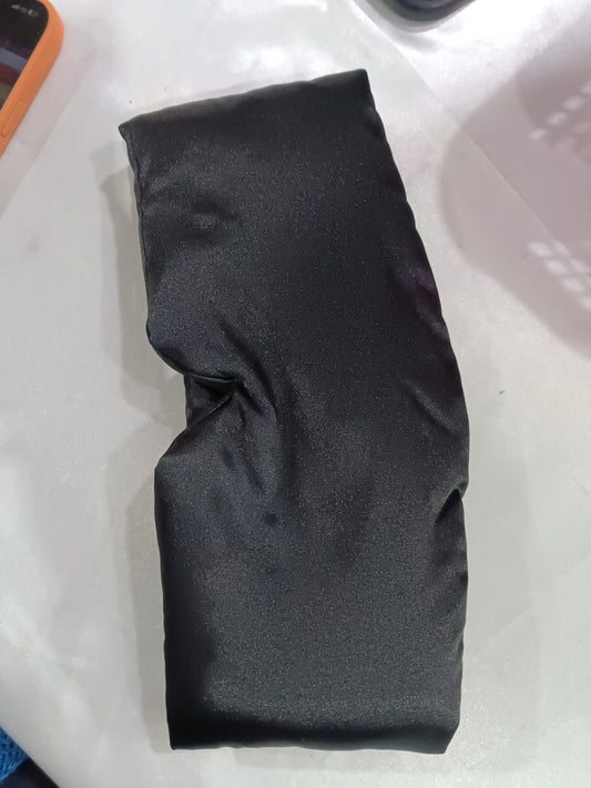Supplier photograph of the black wraparound sleep mask laid flat.